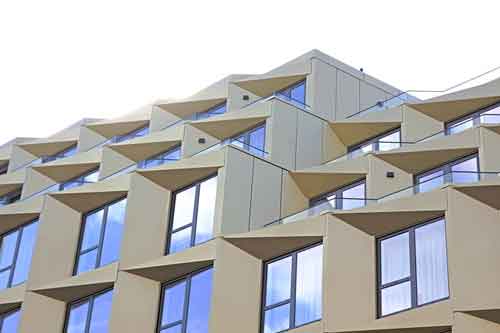 Varios pisos con ventanas con estores y cortinas
